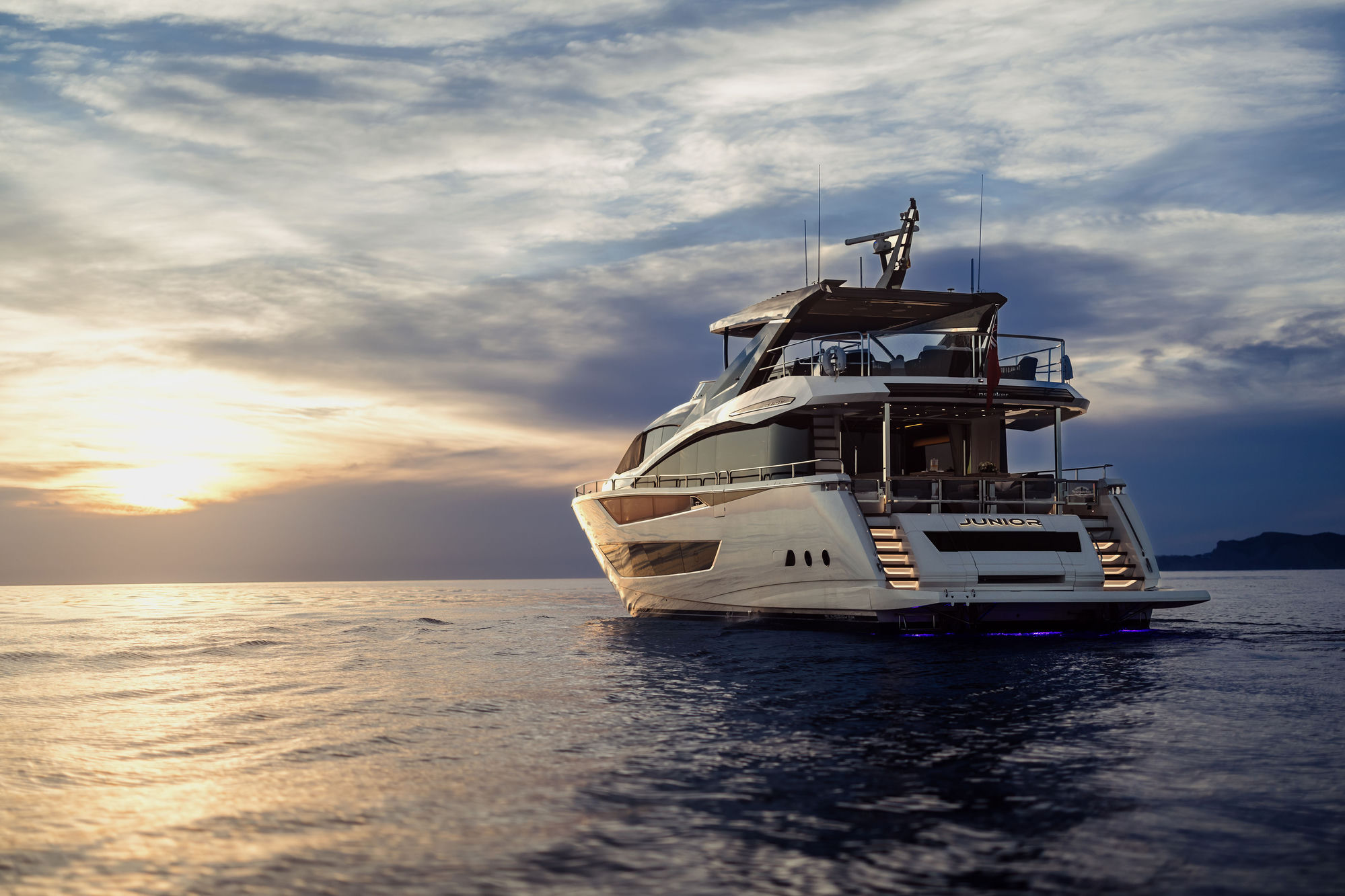 M/Y Junior Sunseeker 88 illuminated at sunset with underwater lights — luxury yacht charter Palma de Mallorca
