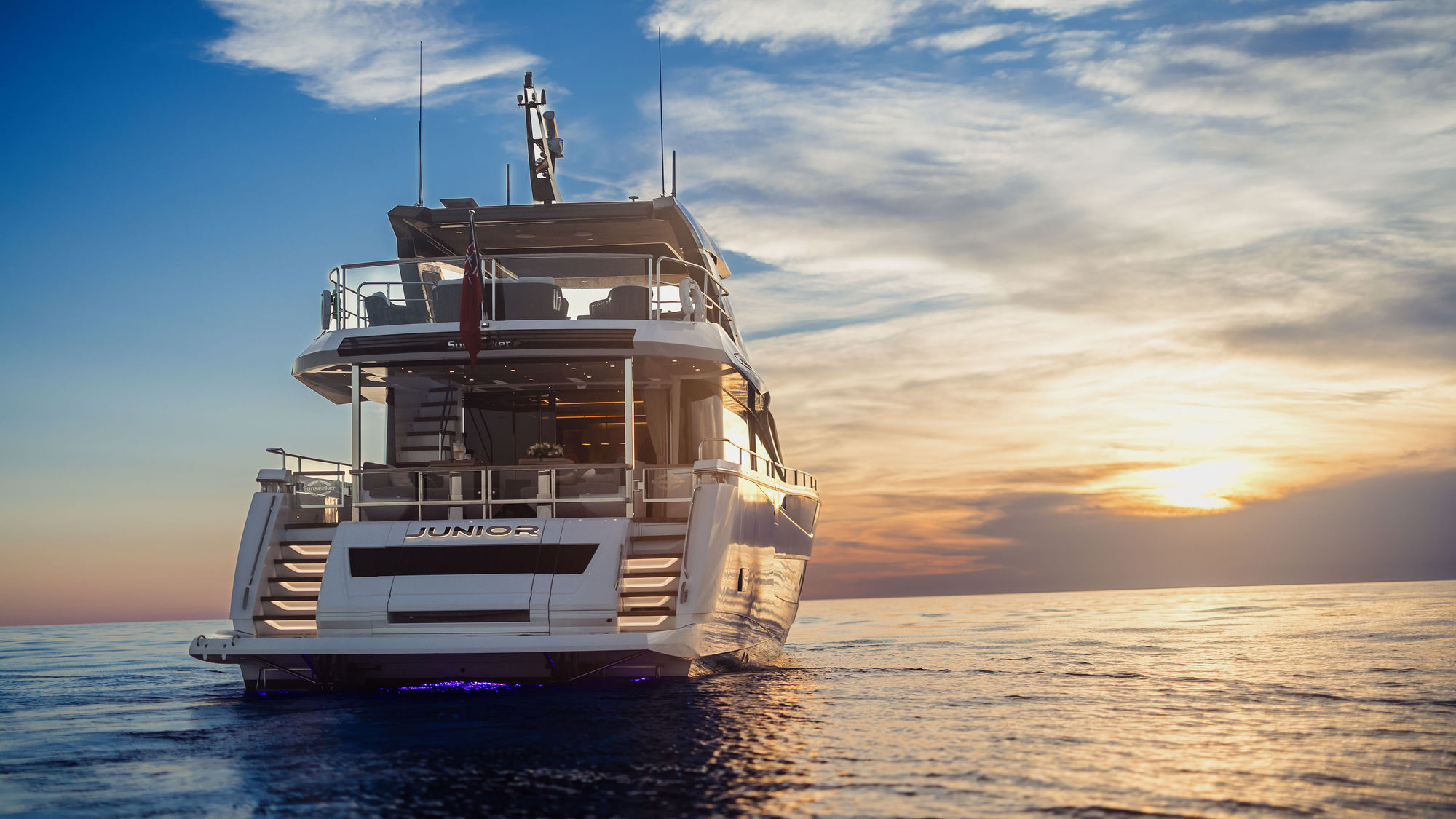 M/Y Junior Sunseeker 88 departing at sunset — luxury yacht charter Mallorca